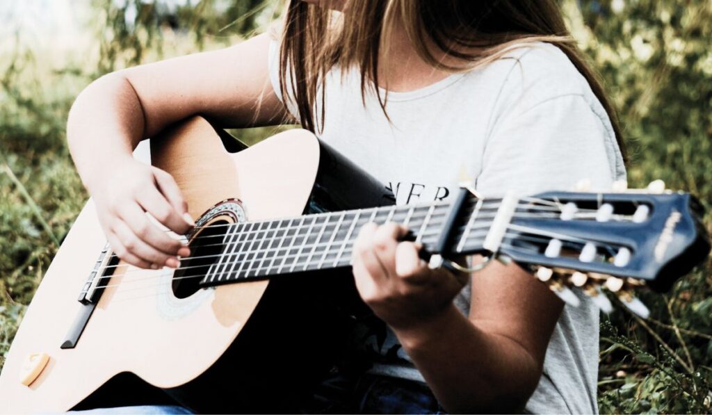 Pessoa a tocar guitarra classica